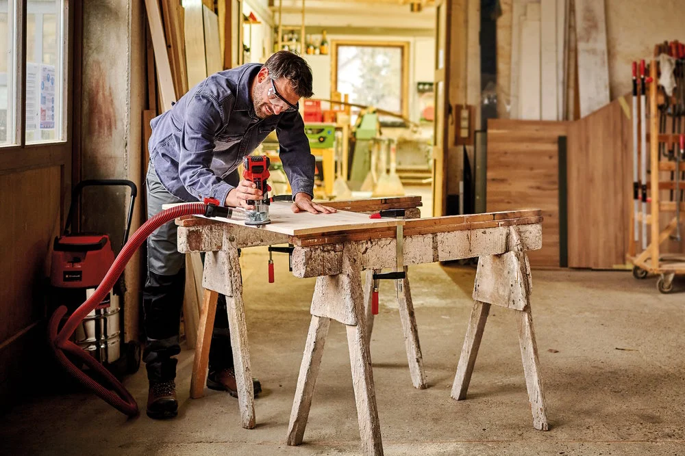 Person bearbeitet Holz mit Oberfräse